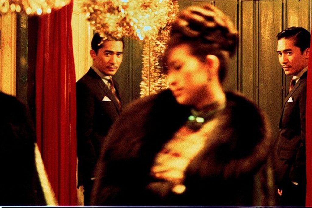 Tony Leung gazes at a blurred Zhang Ziyi in warm, golden light, their reflections and soft focus evoking the hazy, fragmented quality of a memory, one of the main themes of 2046.