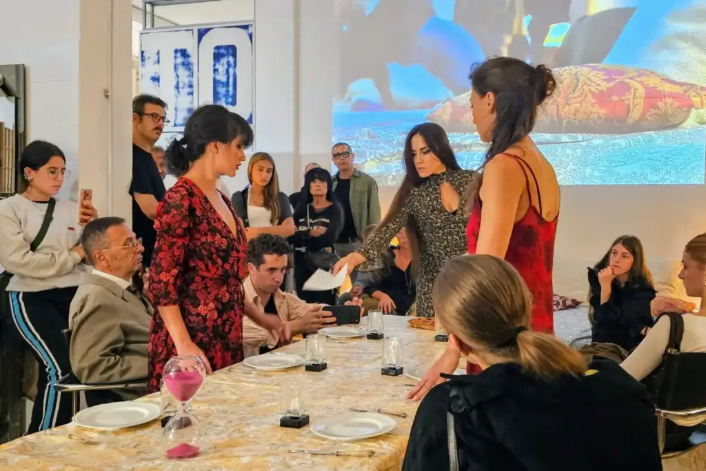 Performers and audience members gathered around a dinner table during Giulia Roversi's contemporary dance performance HOME at Hangartfest 2026.